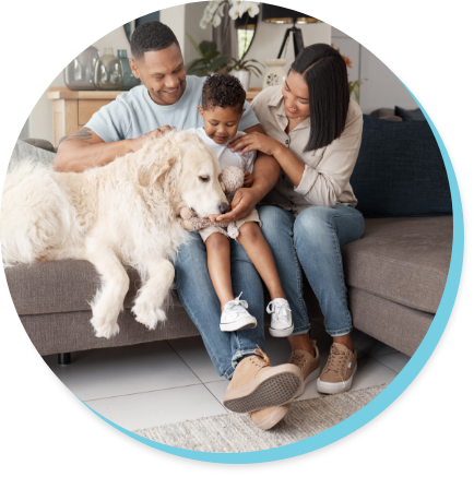 family sitting on couch petting the family dog